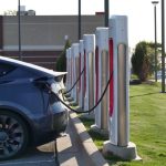 Električni automobil priključen na niz punjača u parkingu